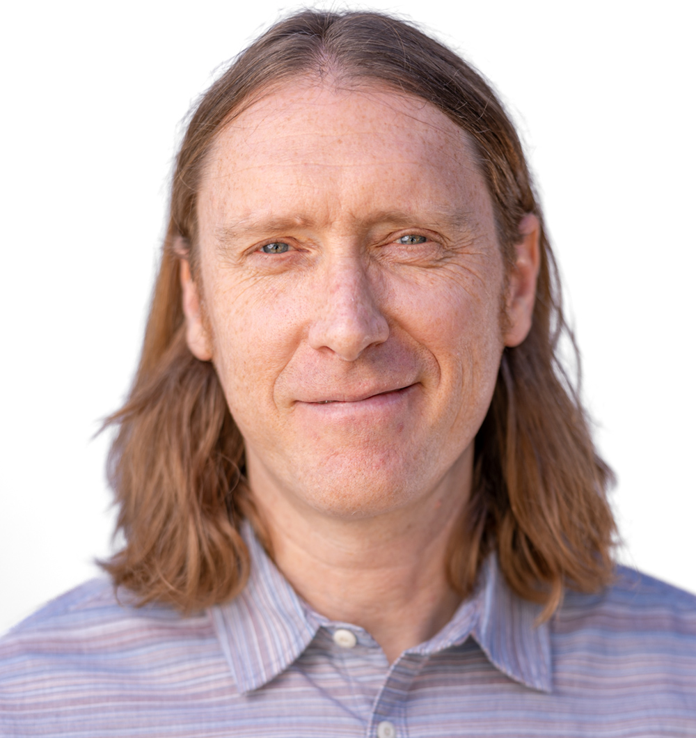 A professional headshot of Brendan Madigan